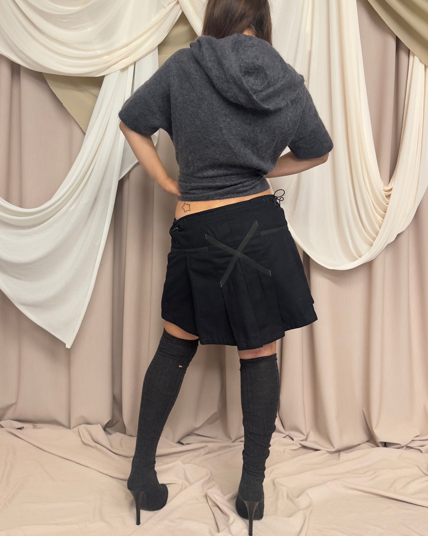 BLACK WOOL PLEATED MINI SKIRT WITH CROSS FRONT DETAIL by Maharishi