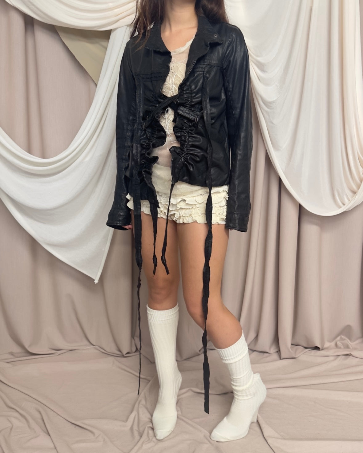 BLACK LEATHER 'BONDAGE' JACKET WITH ASYMMETRICAL HEM AND UTILITARIAN STRAPS by Marithé + François Girbaud